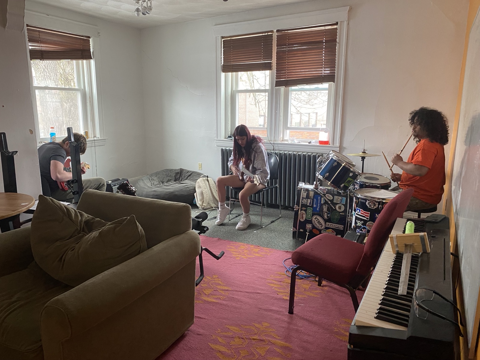 Students playing guitars and drums together in a jam session